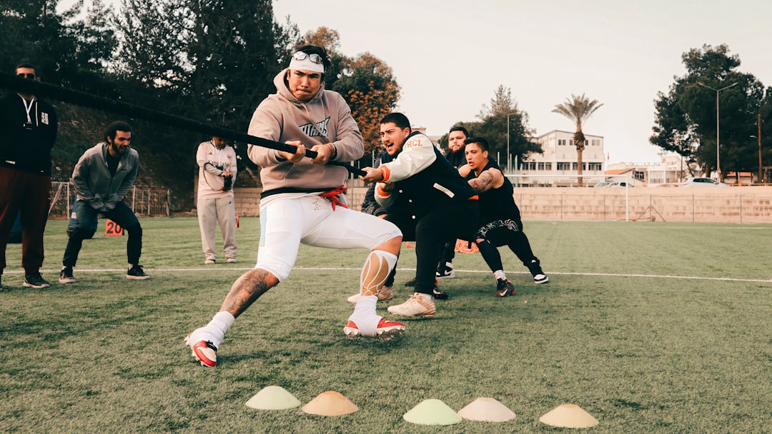 Men playing tug-of-war on a grassy field.