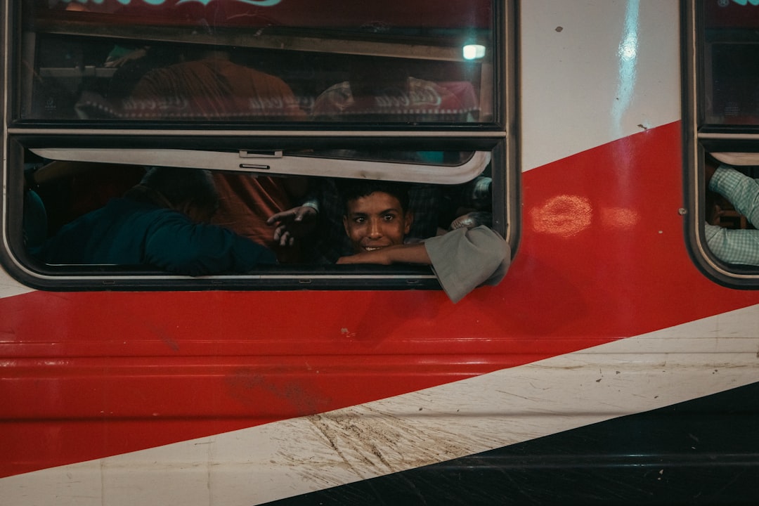 A person looks out a train window with a smile.